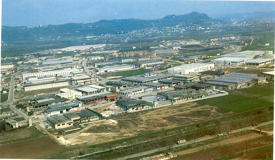丘のふもとに工場の屋根が広がるアルツィニャーノの工業地帯
